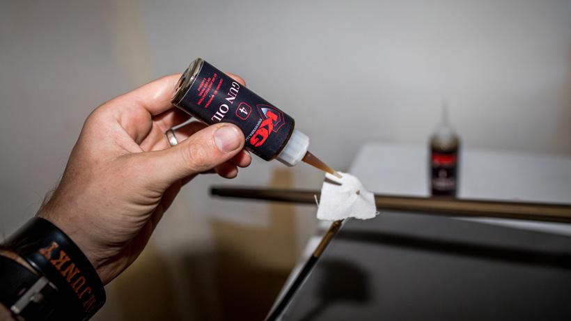 Applying gun oil to rifle bore cleaning patch