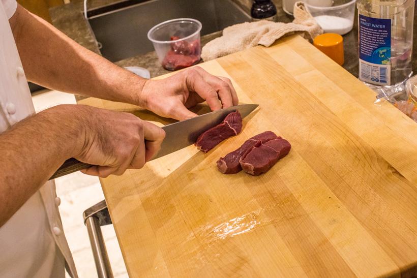 Cutting elk meat into strips