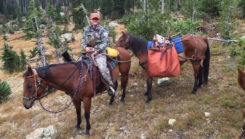 Packing out mule deer on horseback