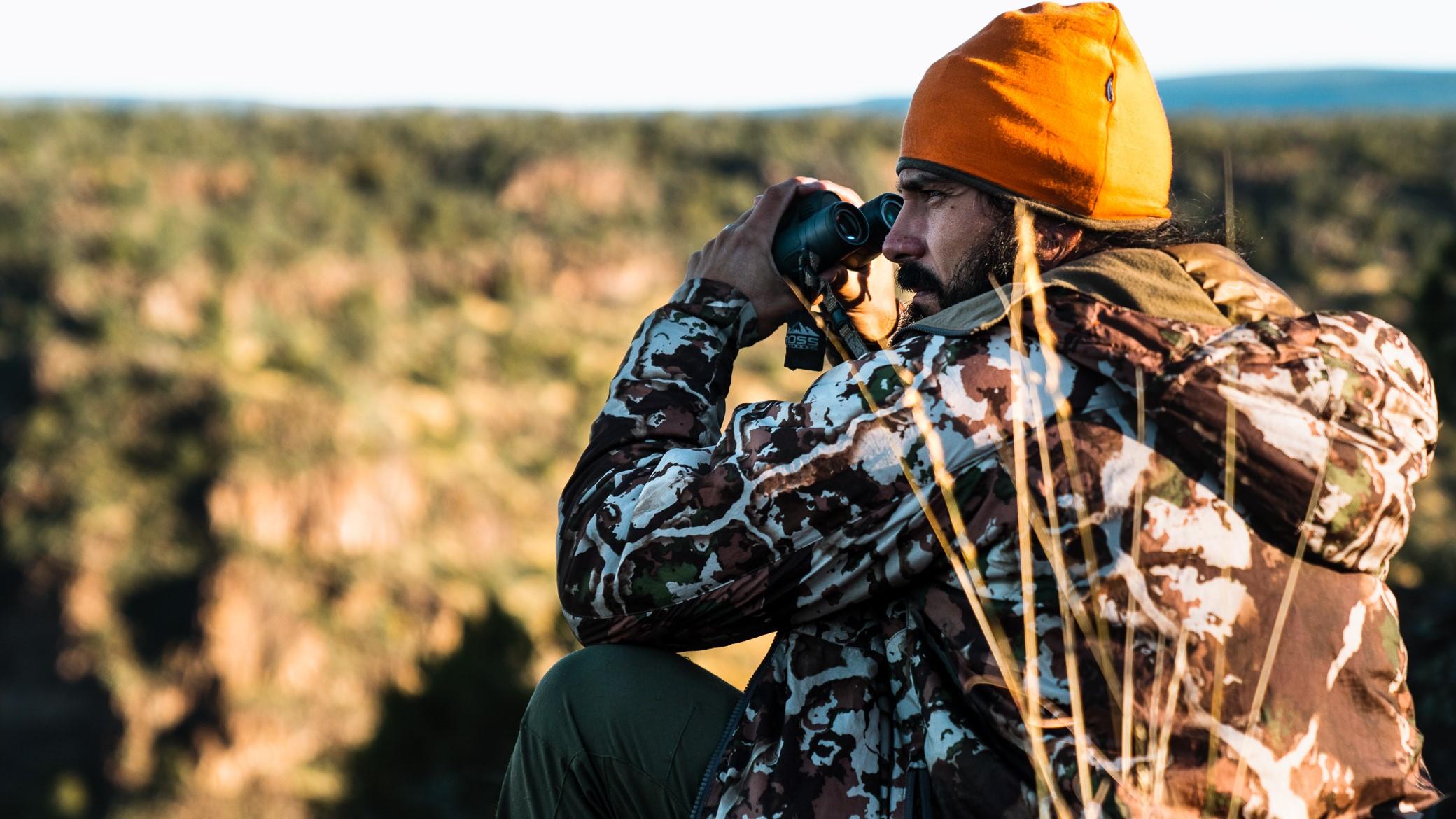 Hunter surveying their surrounding while glassing on a hill