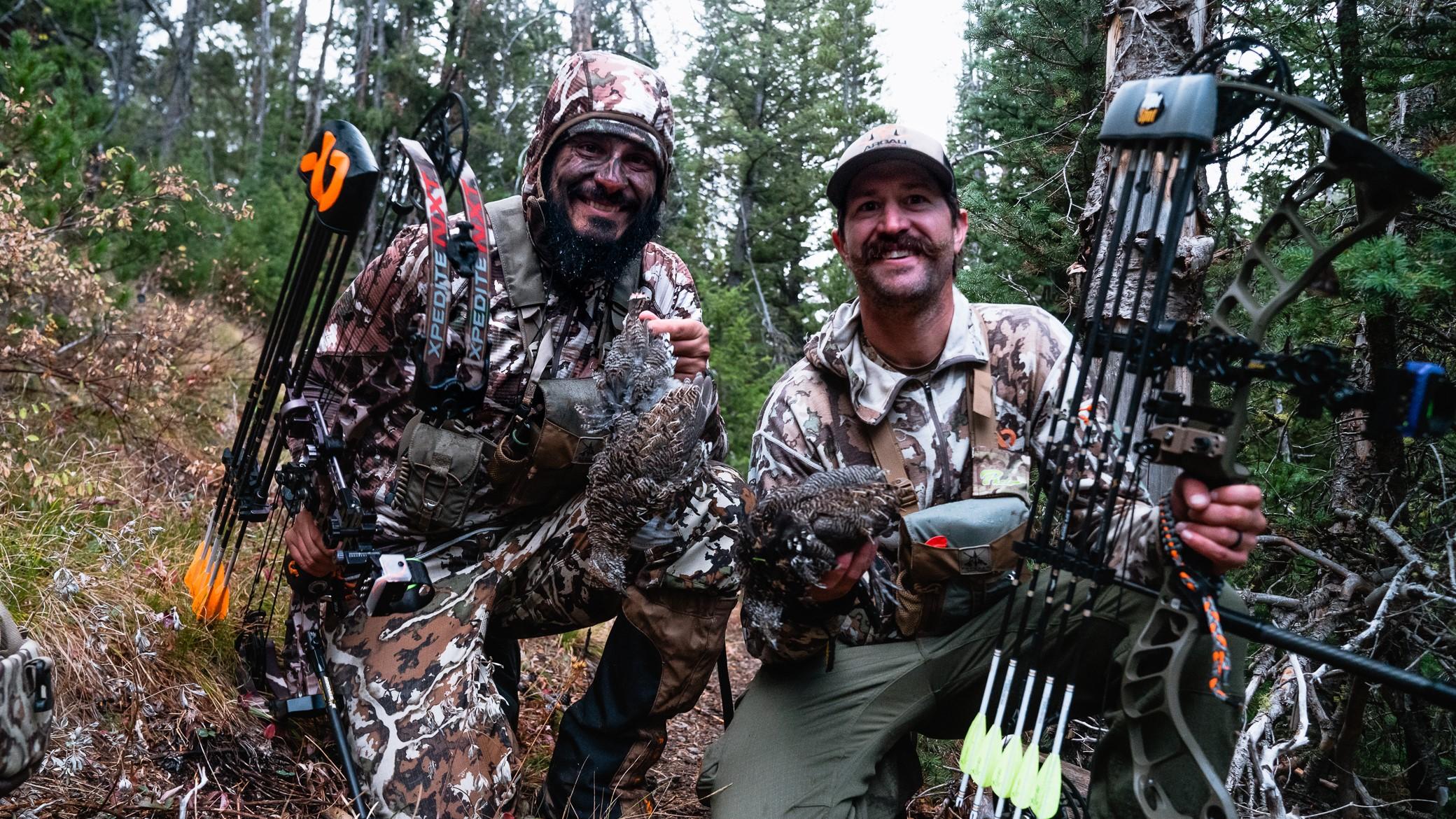 Two bowhunters taking a break and smiling for the camera