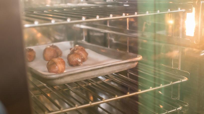 Place elk meatballs wrapped in bacon in oven