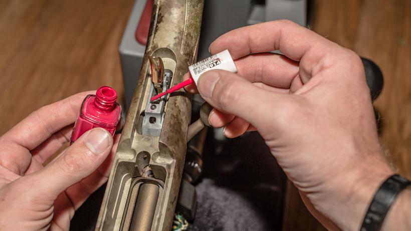 Applying nail polish to rifle trigger adjustment screw