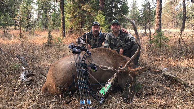 Father and son posing behind their harvested elk