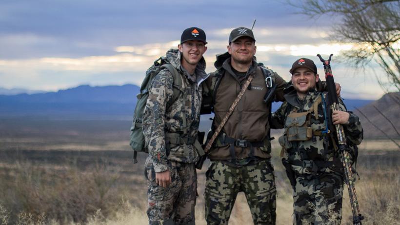 The group of friends all smiles after a coues deer hunt